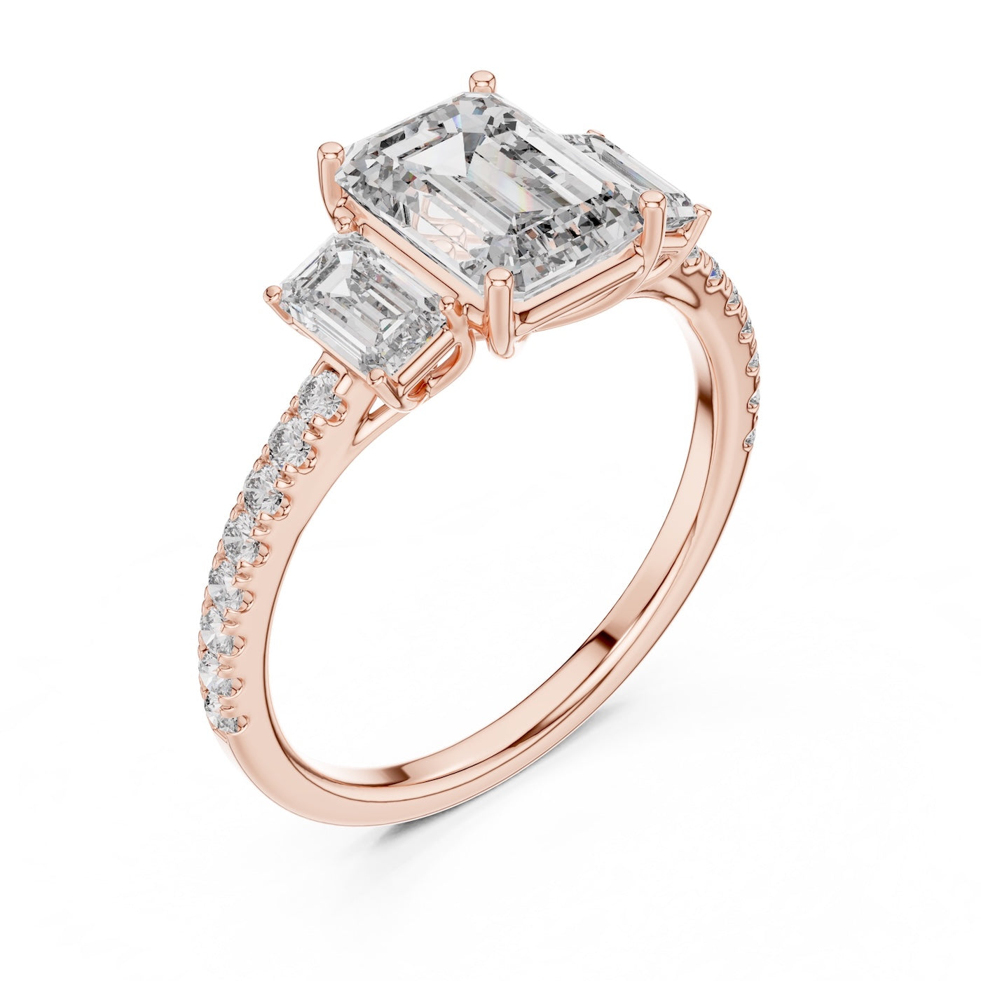 Rose gold ring with emerald-cut diamonds on a white background 