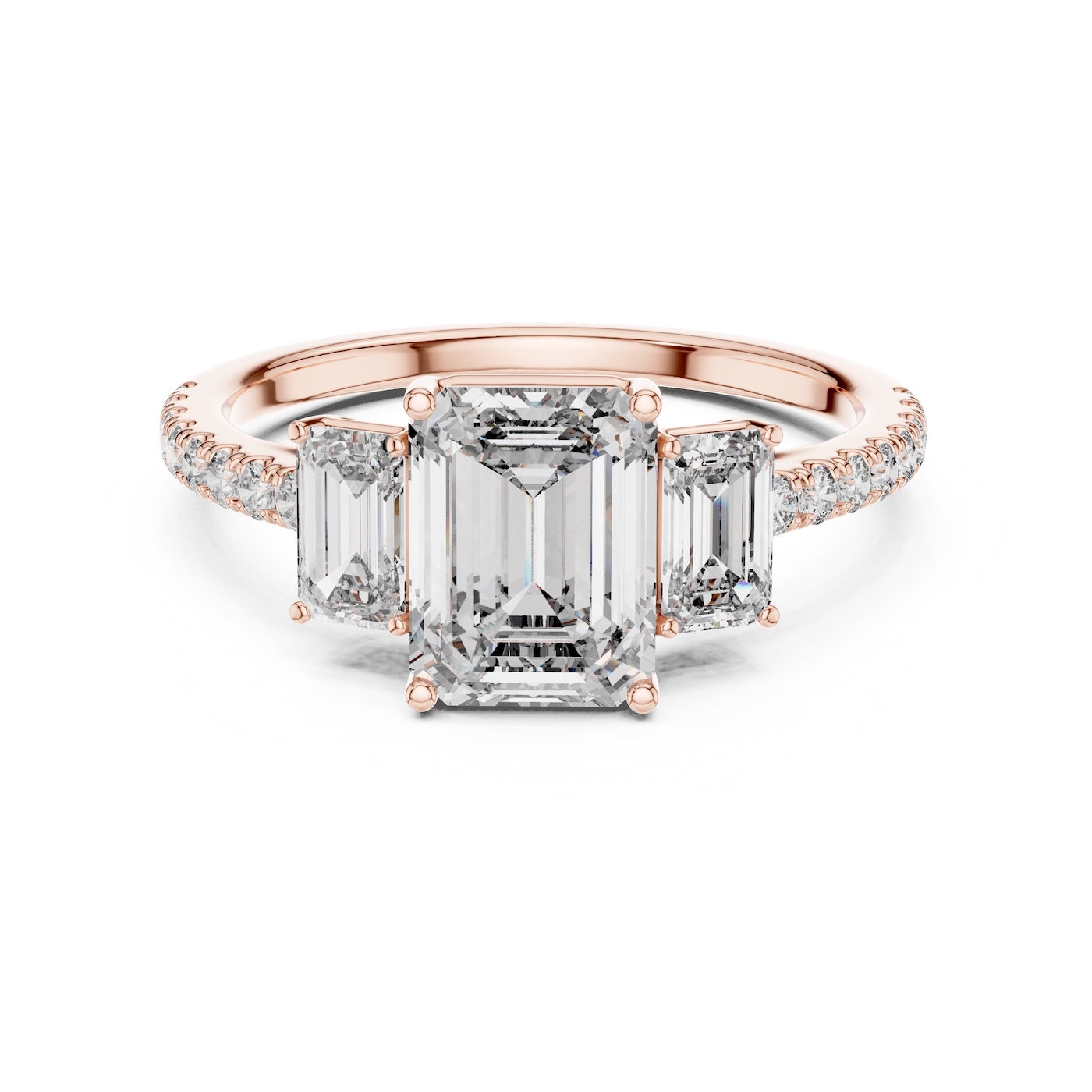Rose gold ring with emerald-cut diamond and smaller diamonds on a white background 