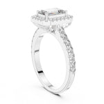 Silver ring with a central emerald-cut stone and halo on a white background 