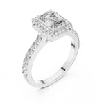 Silver ring with a central emerald-cut stone and halo on a white background 