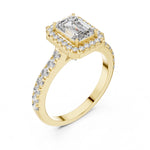 gold plated Silver ring with a central emerald-cut stone and halo on a white background 