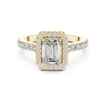 gold plated Silver ring with a central emerald-cut stone and halo on a white background 