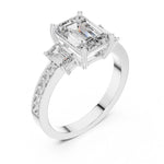 Silver ring with three emerald-cut center stones and smaller round stones on a white background 