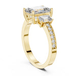 Gold plated Silver ring with three emerald-cut center stones and smaller round stones on a white background 