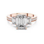 Rose-gold plated Silver ring with three emerald-cut center stones and smaller round stones on a white background 