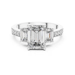 Silver ring with three emerald-cut center stones and smaller round stones on a white background 