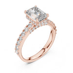 Rose-gold plated Silver ring with a central emerald-cut diamond and smaller diamonds on a white background 