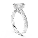 Silver ring with a central emerald-cut diamond and smaller diamonds on a white background 