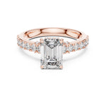 Rose-gold plated Silver ring with a central emerald-cut diamond and smaller diamonds on a white background 