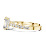 gold plated Silver ring with a central emerald-cut diamond and smaller diamonds on a white background 