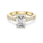 gold plated Silver ring with a central emerald-cut diamond and smaller diamonds on a white background 