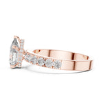 Rose-gold plated silver ring with a pear-shaped center stone on a white background 