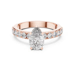 Rose-gold plated silver ring with a pear-shaped center stone on a white background 
